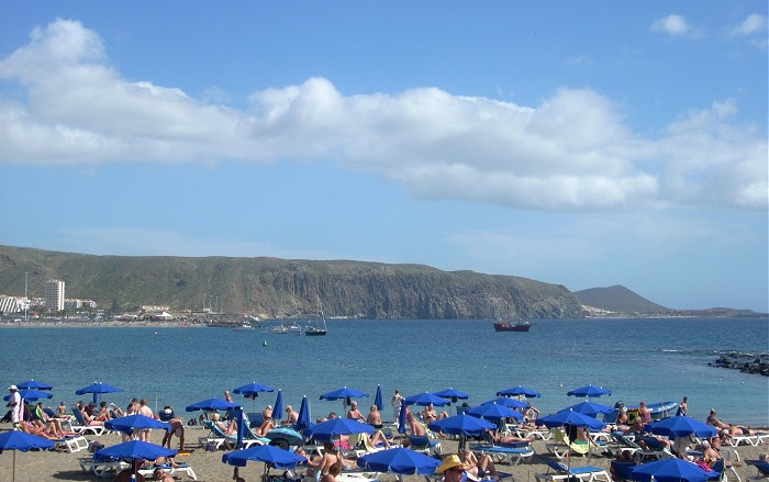 Пляж с голубыми зонтикам