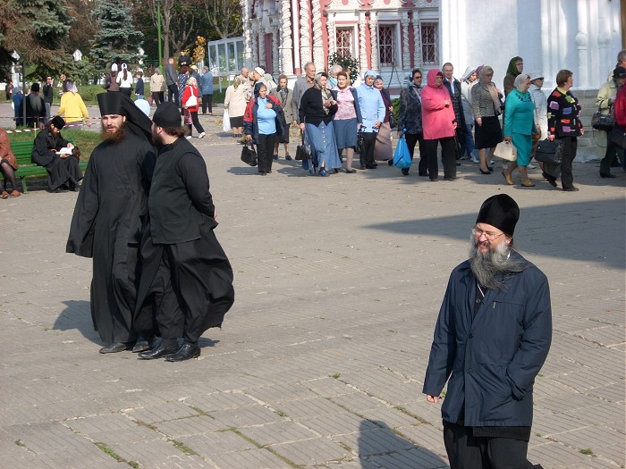группа служителей монастыря и туристы