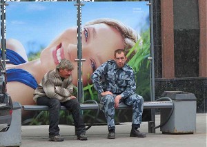 два мужика сидят на фоне портрета девушки