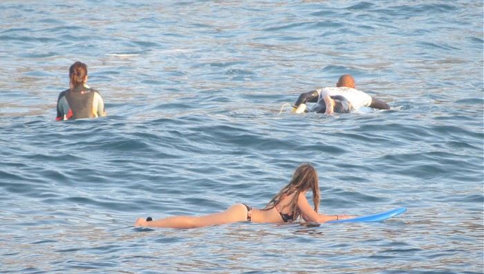 девушка загарает на доске для серфинга